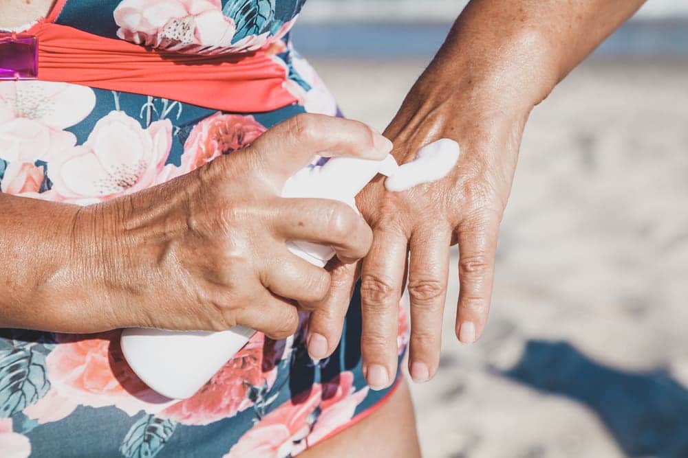elderly women apply sunscreen